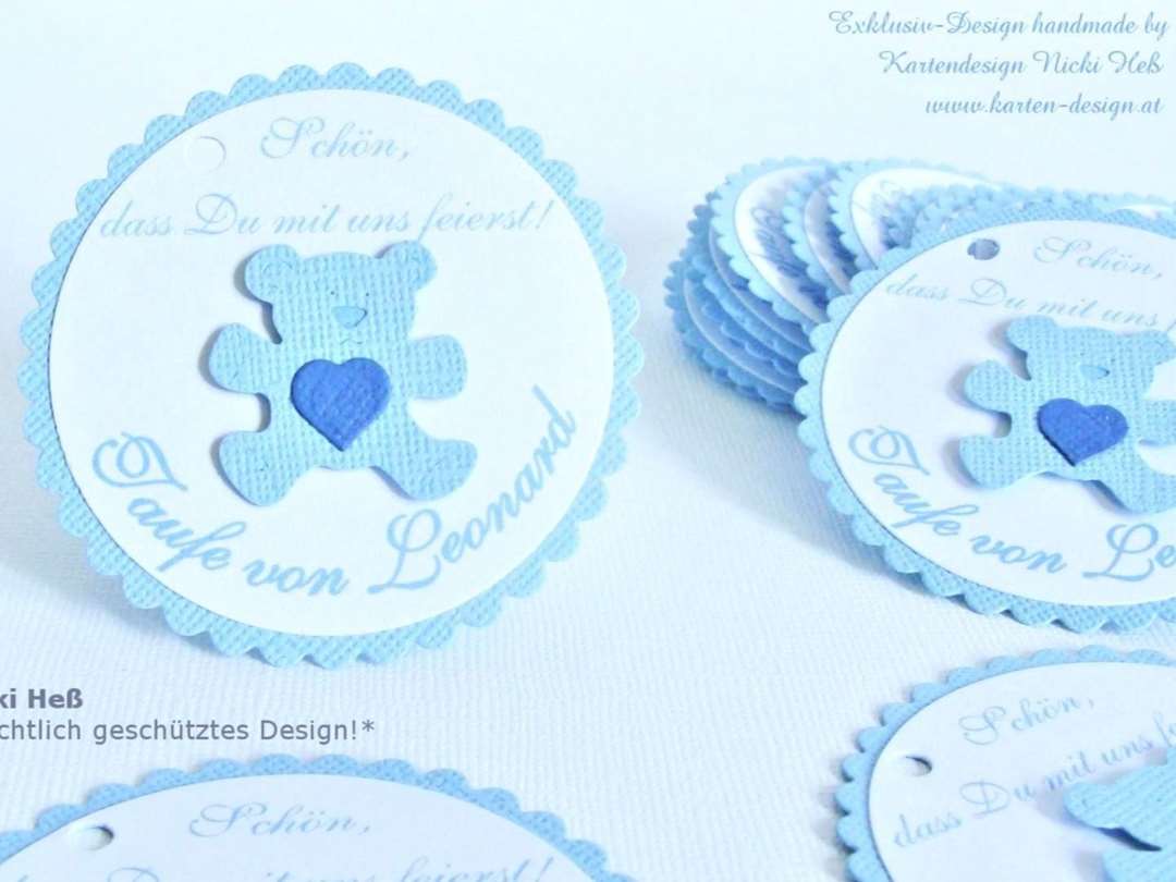 Gewellter DIY Give-Away Anhänger in blau mit personalisiertem Schriftdruck auf weißem Papier darauf. Mittig ist ein kleiner Bär angeordnet. Design Baby Baerchen © KARTEN-DESIGN.at