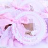 Gastgeschenk Mandelsaeckchen zur Taufe in rosa. Rund gewellter Anhaenger ist mit Taufdaten personalisiert. Mittig darin ist ein Foto angeordnet. Befestigt ist der Anhaenger mit einer rosa gepunkteten Schleife, auf einem Organzasaeckchen, befuellt mit fuenf rosa Taufmandeln. Mandelspruch befindet sich rueckseitig. Design Baby Dreams © KARTEN-DESIGN.at Nicki Heß