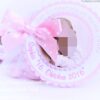 Gastgeschenk Mandelsaeckchen zur Taufe in rosa. Rund gewellter Anhaenger ist mit Taufdaten personalisiert. Mittig darin ist ein Foto angeordnet. Befestigt ist der Anhaenger mit einer rosa gepunkteten Schleife, auf einem Organzasaeckchen, befuellt mit fuenf rosa Taufmandeln. Mandelspruch befindet sich rueckseitig. Design Baby Dreams © KARTEN-DESIGN.at Nicki Heß