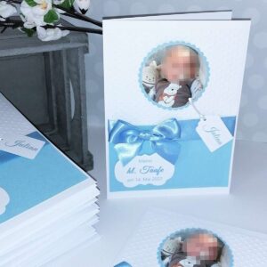 Handgefertigtes weißes Kirchenheft - Design: Sweet Baby, in Wunschfarbe Blau mit Babyfoto und Namensanhänger. Taufheft im geprägten Design mit Satin-Schleife in Baby-Blau und personalisierten Text. © KARTEN-DESIGN.at