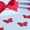 Niedliche handgefertigte Streu-Deko Schmetterlinge für die Taufe in rot. Zur Verwendung als Tischdekoration oder DIY-Taufe in vielen weiteren Farben im karten-design Shop erhältlich. © karten-design.at