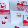 Taufeinladung "Sweet Circle" in Rot personalisiert mit 3D-Schmetterling und Pünktchenband in Baby-Rot. Taufkarte mit personalisierter Kuvertgestaltung mit Foto vom Baby. © KARTEN-DESIGN.at