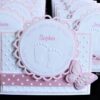 Tischkarte zur Taufe, Design Beautiful Baby, in rosa mit personalisiertem Label, geprägten Babyfuessen, rosa-weiß getupftes Band und 3D-Schmetterling. ©KARTEN-DESIGN.at