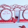 Handgefertigte Tischkarte zur Taufe, Design Beautiful Baby, in rot mit personalisiertem Label, geprägten Babyfuessen, rot-weiß getupftes Band und 3D-Schmetterling. ©KARTEN-DESIGN.at