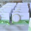 Handgefertigte Tischkarte in weiß mit karierten gruenen Karo-Papierstreifen im unteren Bereich mit Taftband darauf. Gepraegte Babyfuesse auf einem gewellten Kreis sind darauf angeordnet. Rechts ist mittig der Gaestename aufgedruckt. Design: First-Lovely-Times ©KARTEN-DESIGN.at