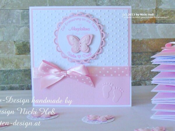 Dankeskarte für die Gäste der Taufe in Rosa mit weiß gepunkteten Hintergrund. Darauf ist ein gewelltes Label in Rosa mit einem personalisierten Dankestext. Mittig ist ein 3D-Schmetterling angeordnet. Ein rosa Tupfenband und Babyfüsschen zieren die Danksagungskarte zur Taufe. © KARTEN-DESIGN.at